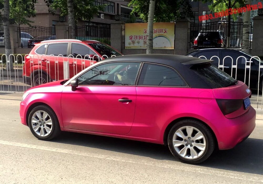 audi rose garee dans une rue animee