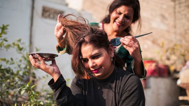 Comment le henné peut-il transformer vos soins capillaires 37 femme appliquant du henne sur cheveux